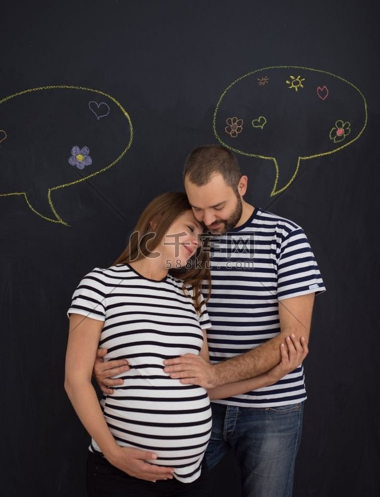 丈夫和怀孕的妻子在黑色粉笔画板