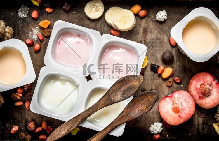 各种水果酸奶。在一个木制的背景