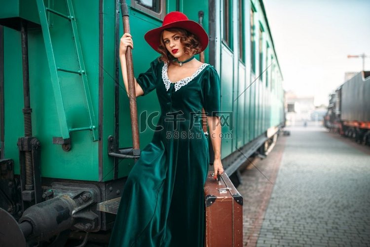 女人在红帽子反对旧铁路货车。复