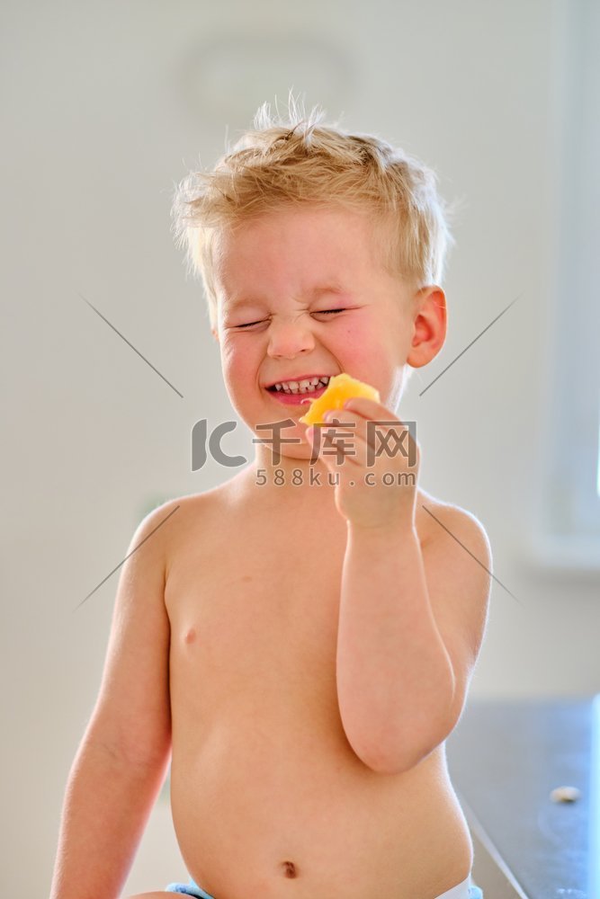 吃酸水果的两岁男孩