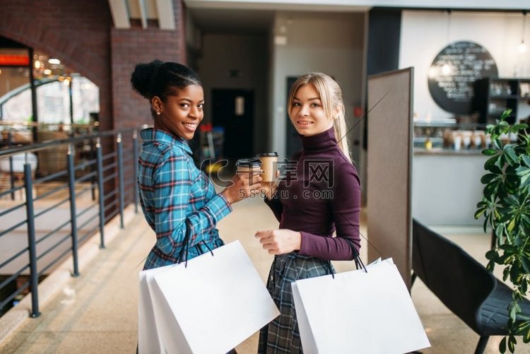白人和黑人女性顾客与购物袋在商