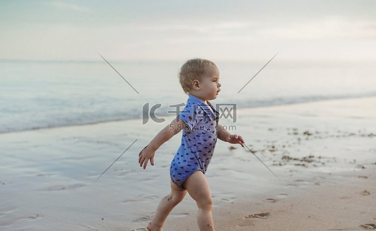 小可爱的男孩沿着海边走