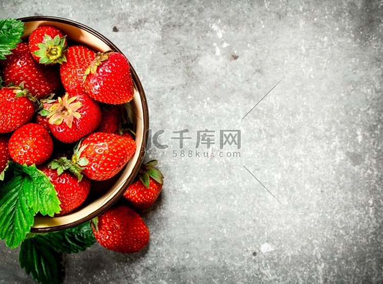盛在碗里的成熟草莓。在石桌上.
