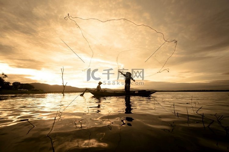 泰国阳光船上渔民用网捕鱼的剪影