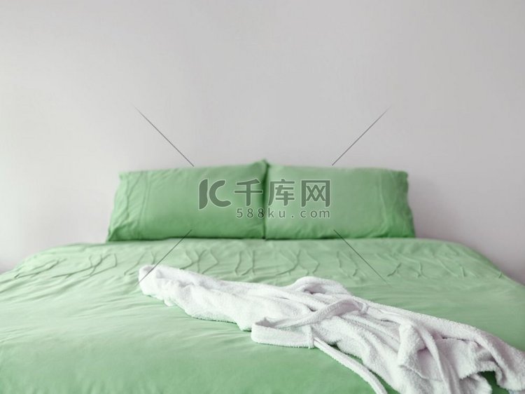 绿色床和浴袍的照片