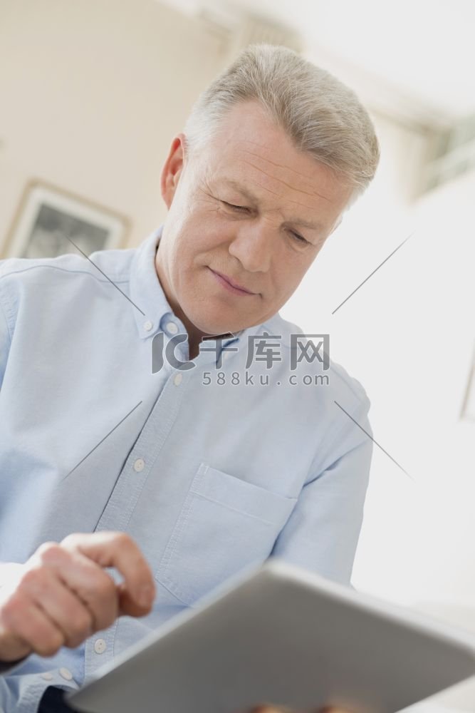 成熟男性在家使用数字平板电脑