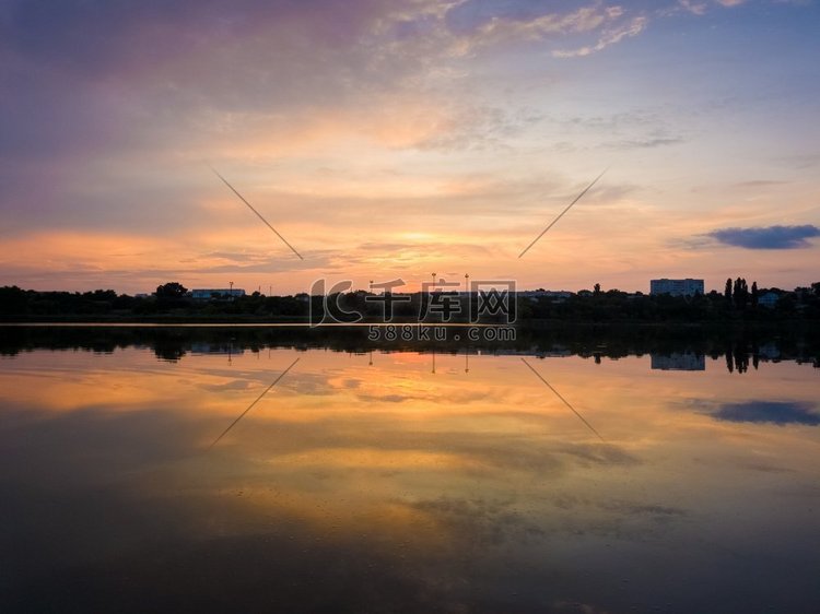 五颜六色的夕阳云对称地反射在湖