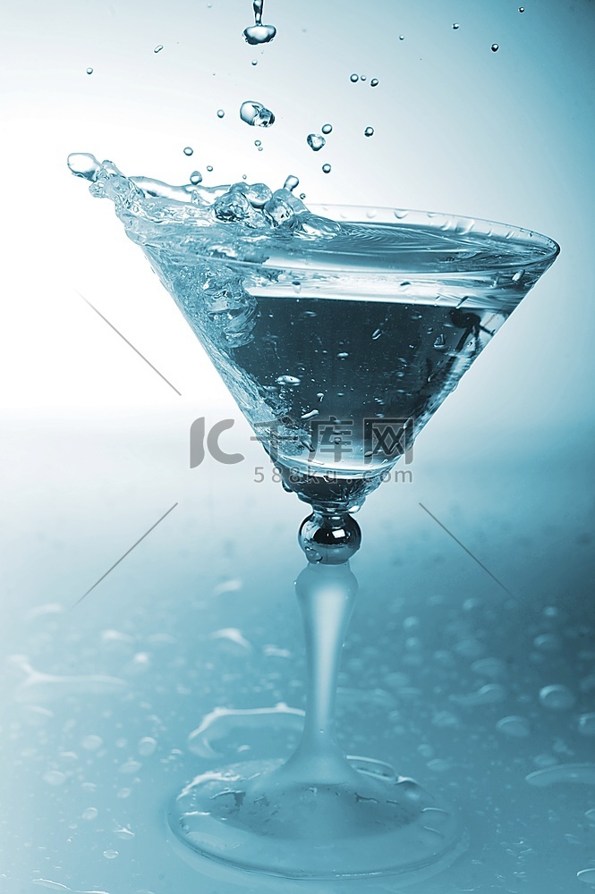 鸡尾酒杯中的冰冷透明水和水花