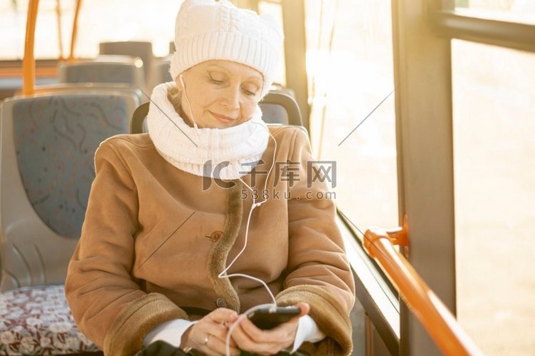 高角度老年妇女巴士听音乐