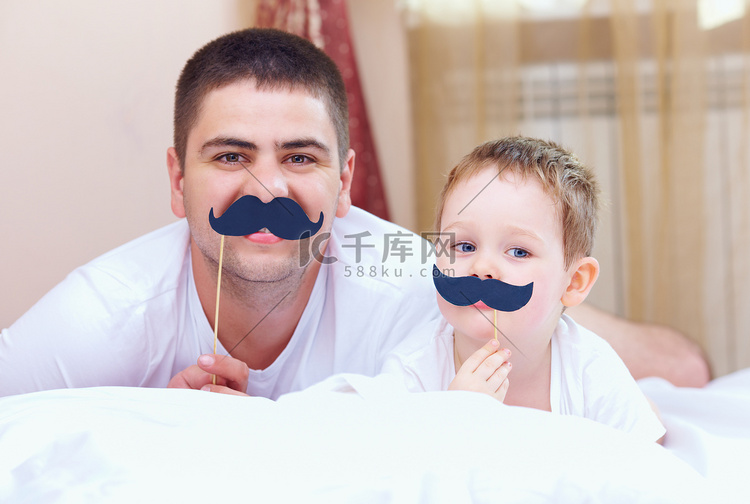 有趣的父亲和儿子一起假胡须，在