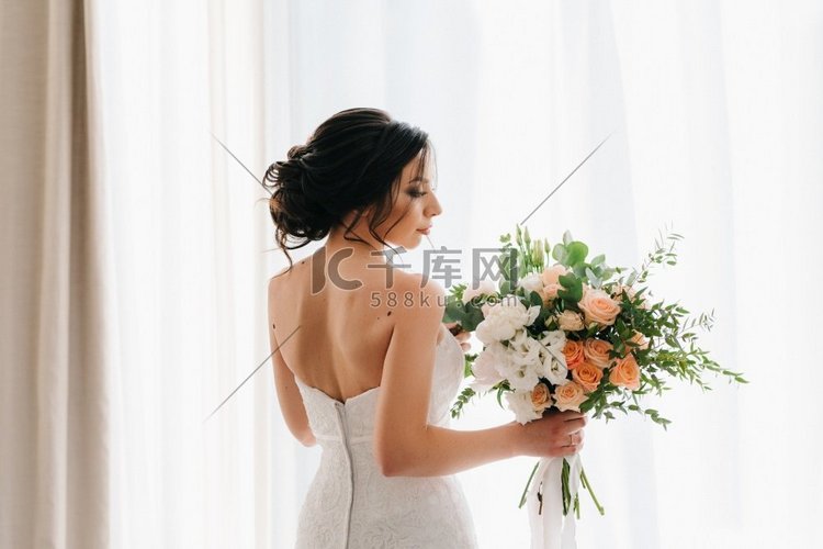 新娘在一个白色的礼服与花束在酒