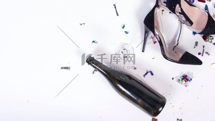 妇女黑色高跟鞋躺在靠近瓶子后党