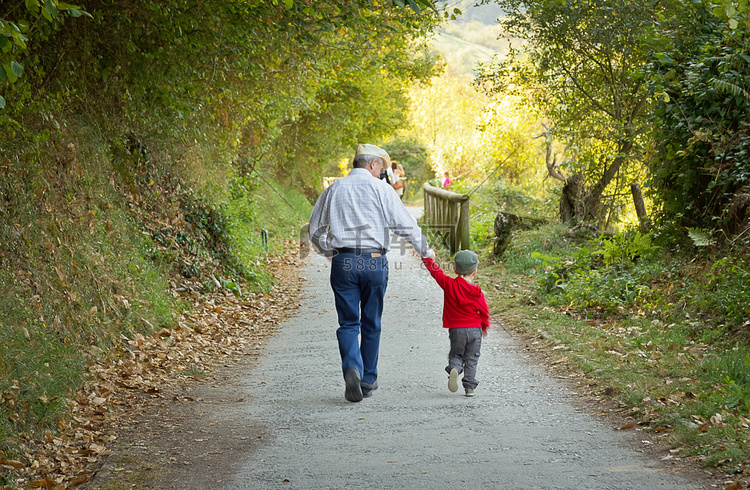 爷爷和孙子走在大自然路径