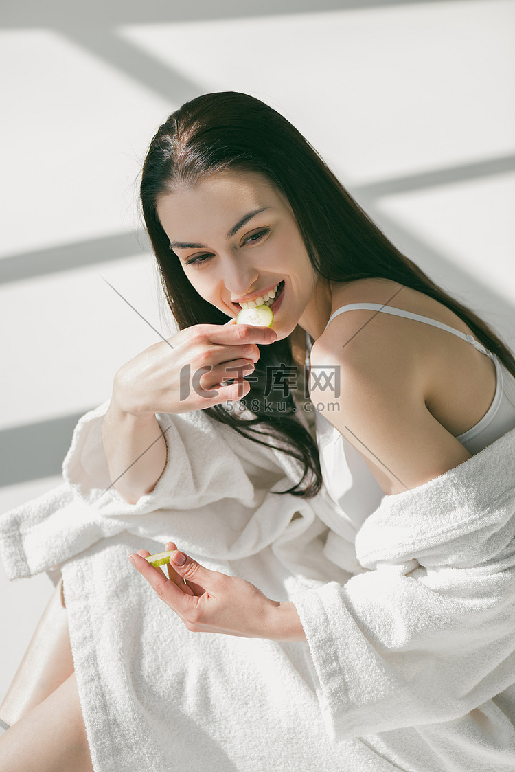 微笑的女人吃片黄瓜
