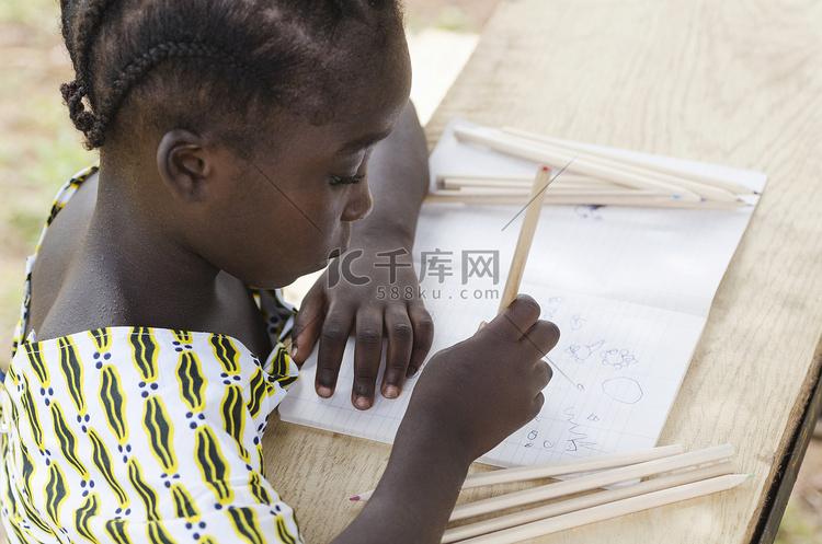 年轻的女孩坐在和写在纸上