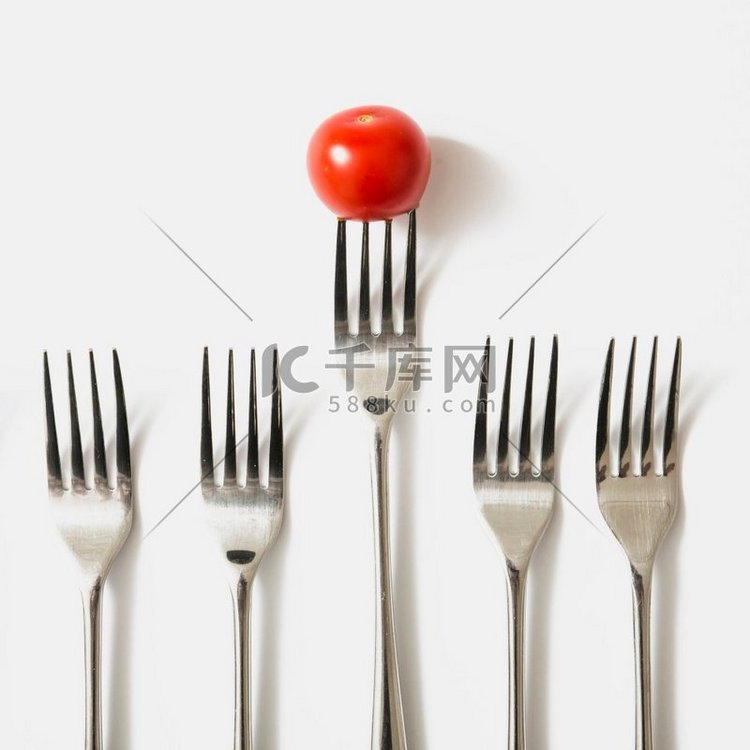 红色樱桃番茄叉反对白色背景。漂
