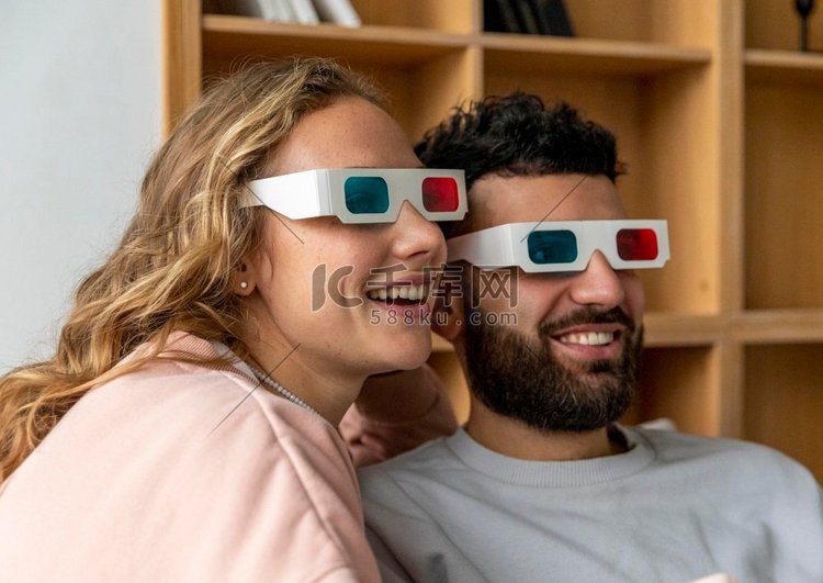 微笑的夫妇看电影家与三维眼镜