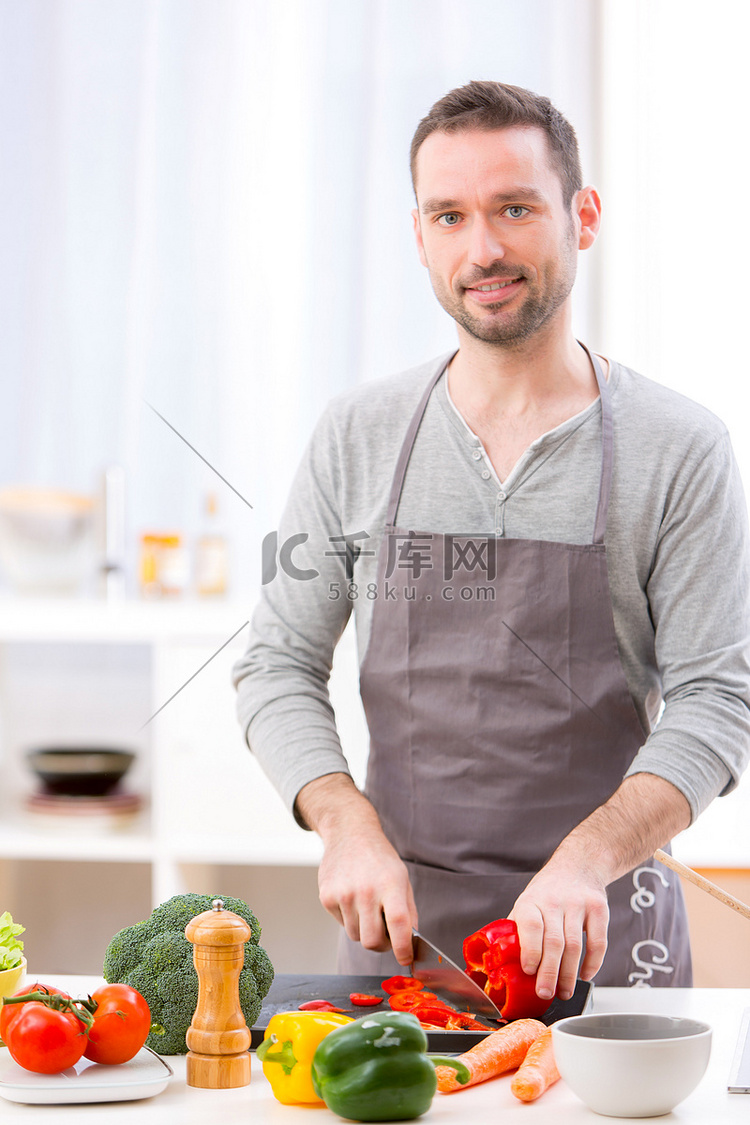 年轻有魅力的男人在厨房做饭