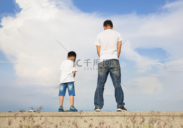 父亲和儿子站在石头平台和小便在