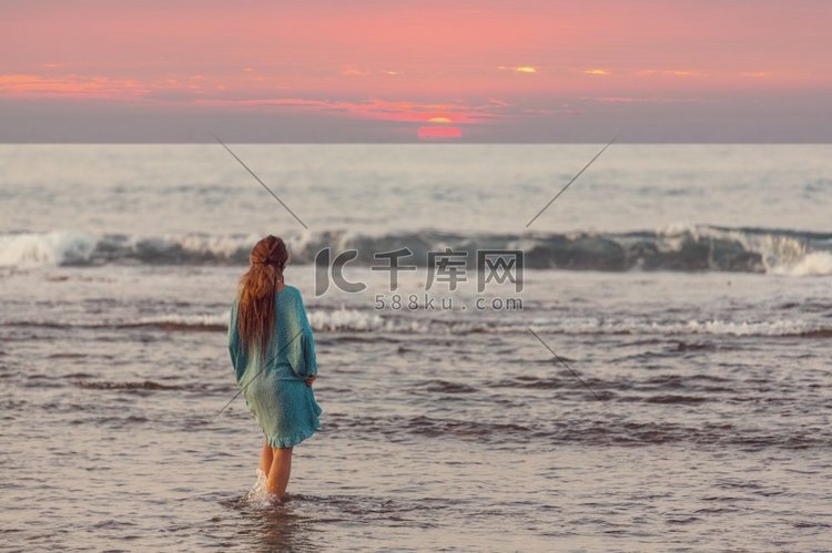 夕阳下的海滩上的女孩