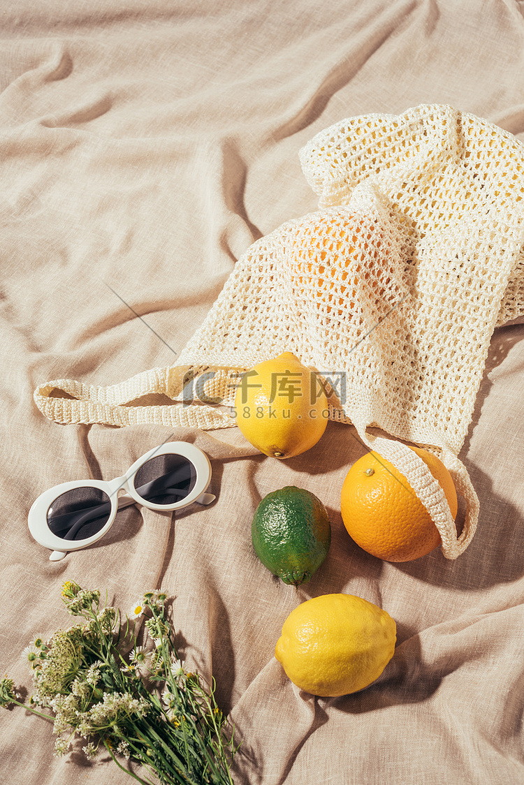 太阳镜、鲜花和带热带水果的弦袋