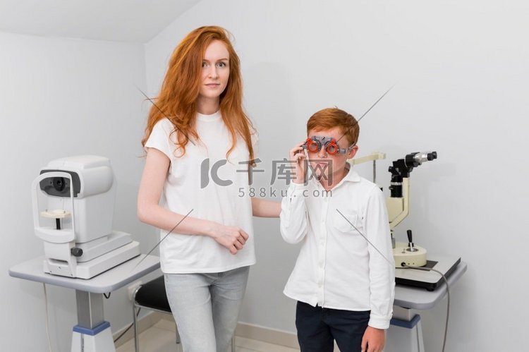 年轻的女配镜师在检查男孩患者的