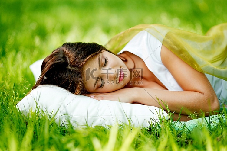 睡在柔软的枕头上的年轻女子，睡
