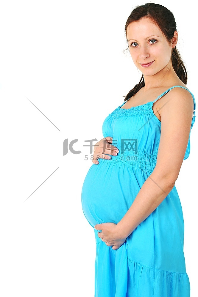 身着蓝色连衣裙的美丽孕妇。肖像