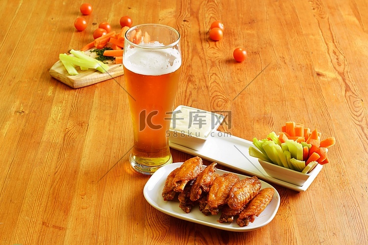 鸡翅配芹菜、胡萝卜和一杯啤酒