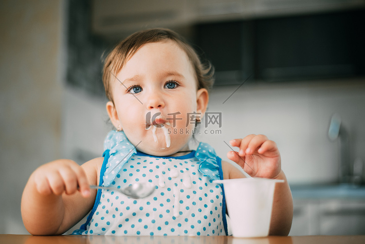 可爱,有趣的女孩吃酸奶在白天在