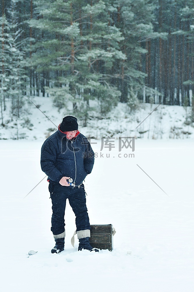 冬季冰上钓鱼。渔夫从冰洞里捕鱼