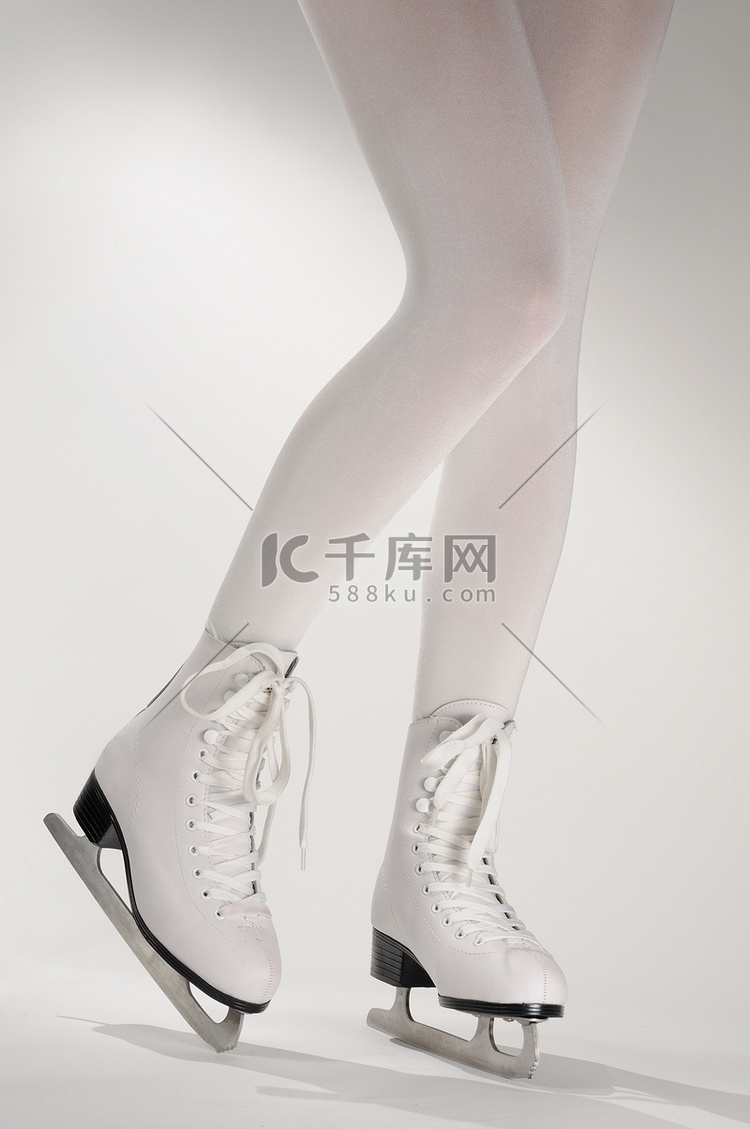 女人的腿在白色溜冰鞋