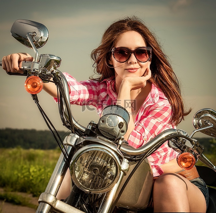 戴墨镜的摩托女孩坐在摩托车上