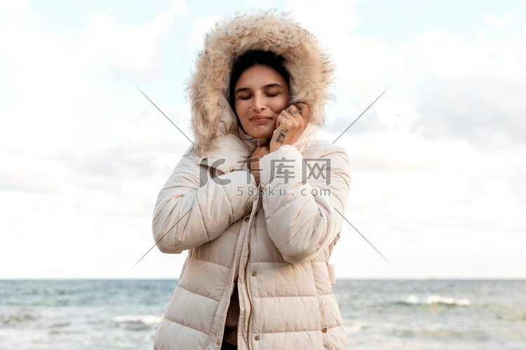 微笑的女人海滩与冬季夹克