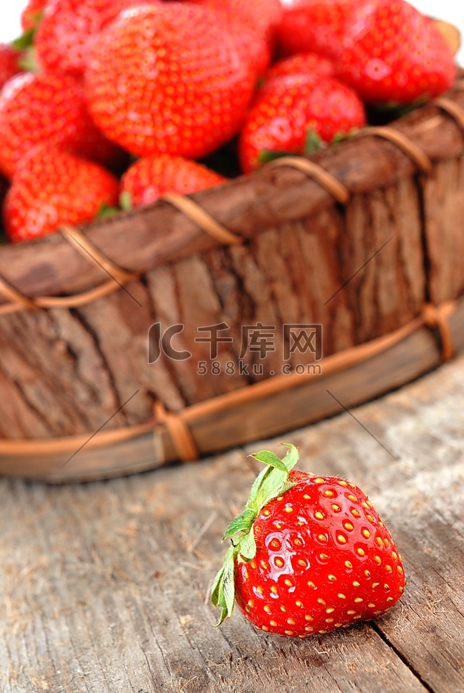 一篮子新鲜草莓，装在木板上