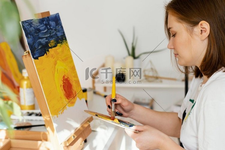 一名年轻女子在家中用丙烯酸作画