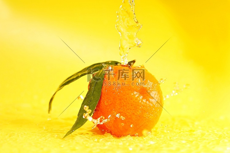 橘子和水溅在黄色上，特写