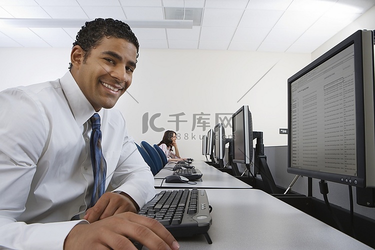 男人坐在电脑前的办公桌前