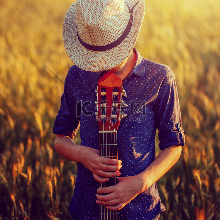 十几岁的男孩在与声学吉他，在户