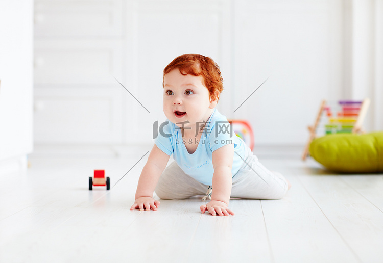 可爱的婴儿宝宝在家里的地板上爬