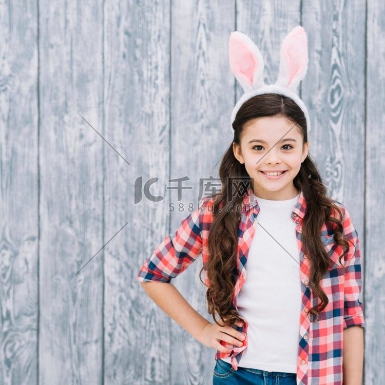 肖像自信微笑的女孩与兔子耳朵头