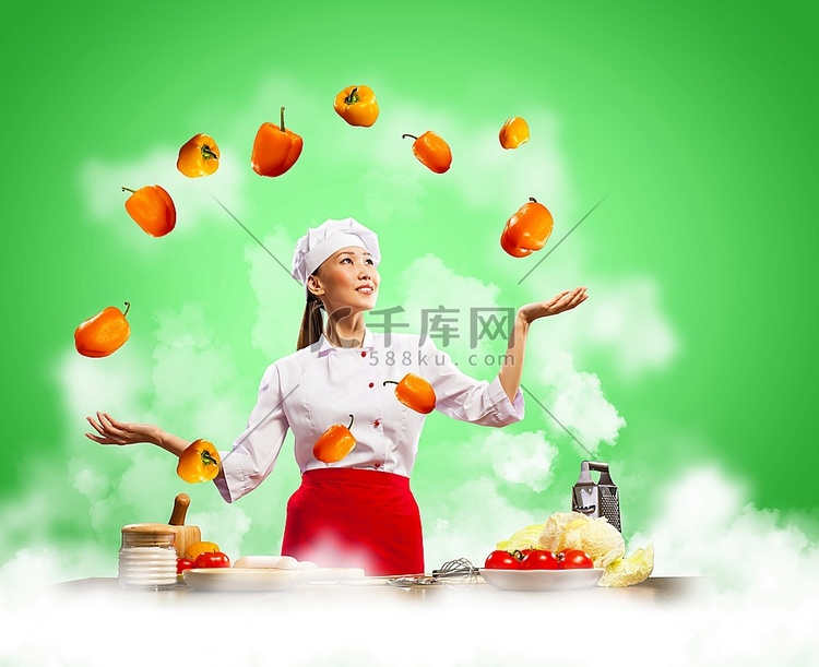在彩色背景下玩杂耍的亚洲女厨师