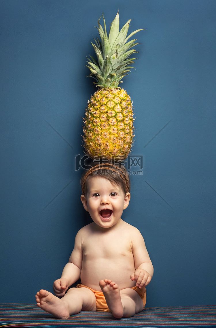 快乐宝贝女孩举行一个菠萝在她的