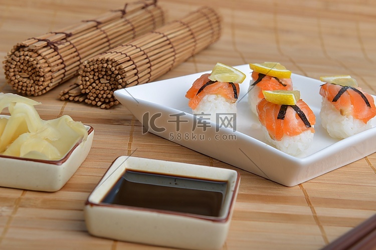 一盘三文鱼寿司铺在竹纸上