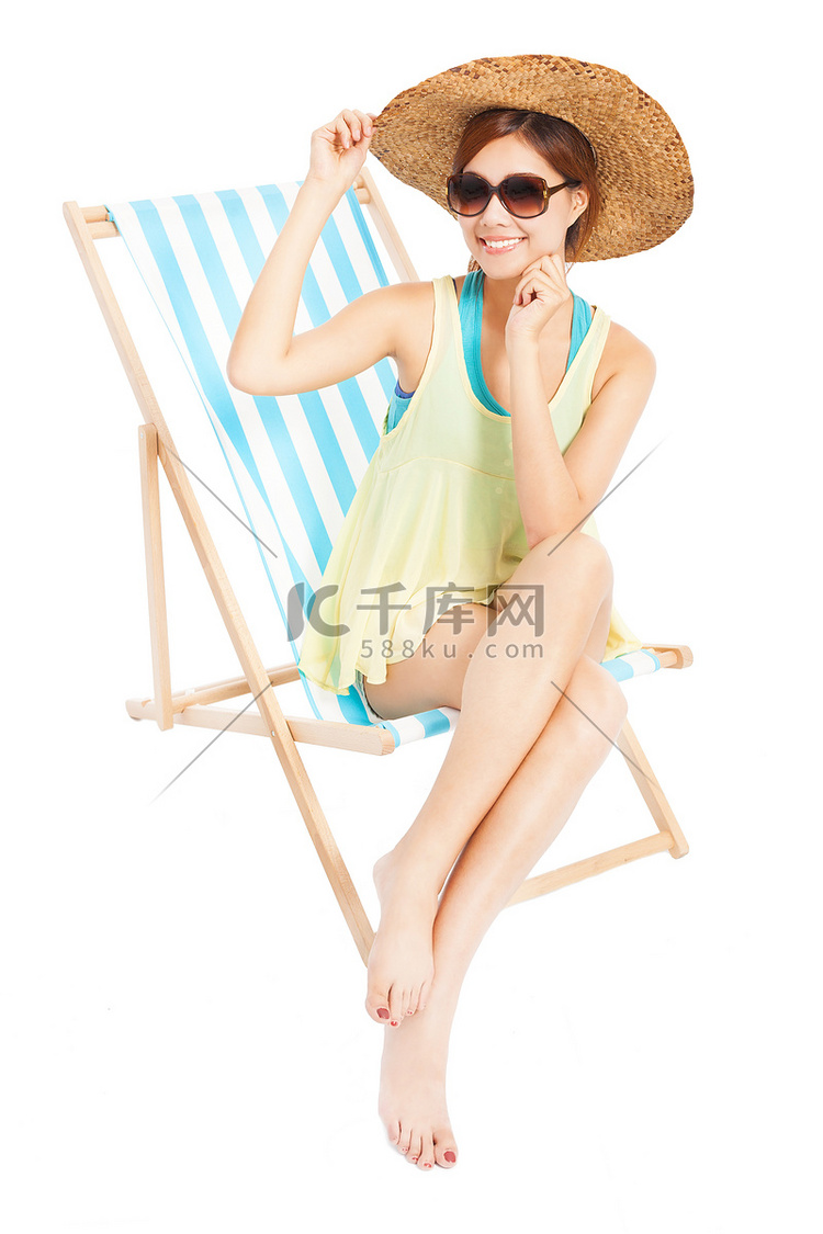 年轻时尚的女人微笑，坐在沙滩椅