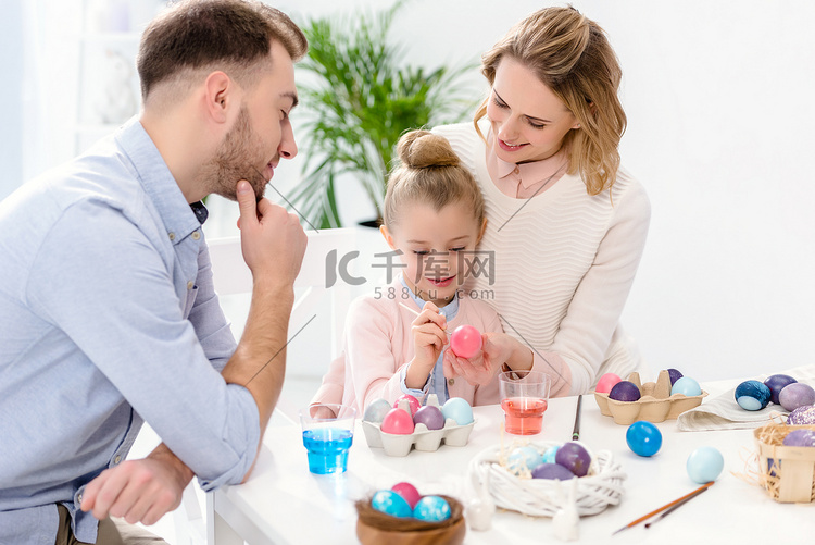 父母和女儿用不同的颜色画复活节