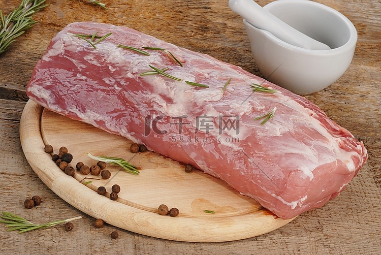 用迷迭香将新鲜生肉放在切菜板上