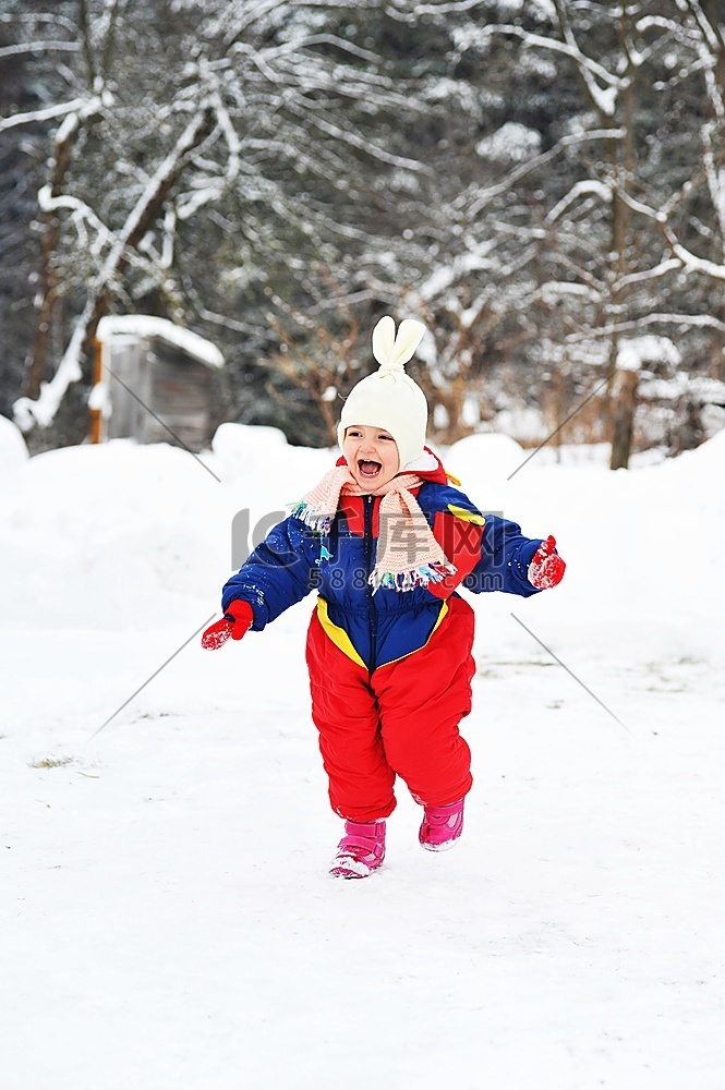 冬天穿着大衣的快乐女孩在雪地上