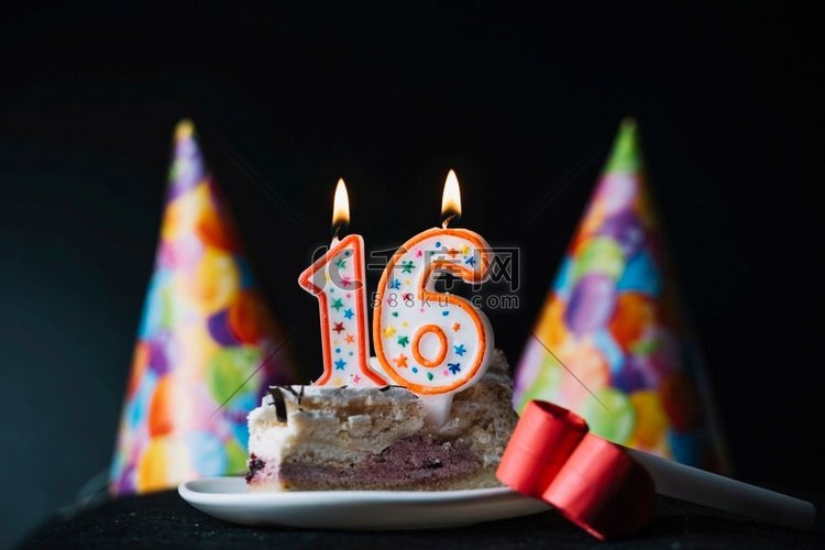 16号生日点燃蜡烛片蛋糕与党帽