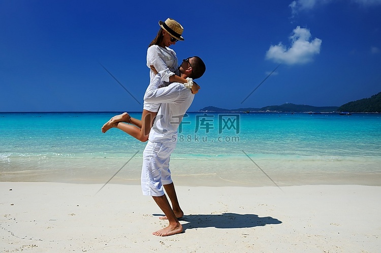 热带海滩上的一对白衣情侣